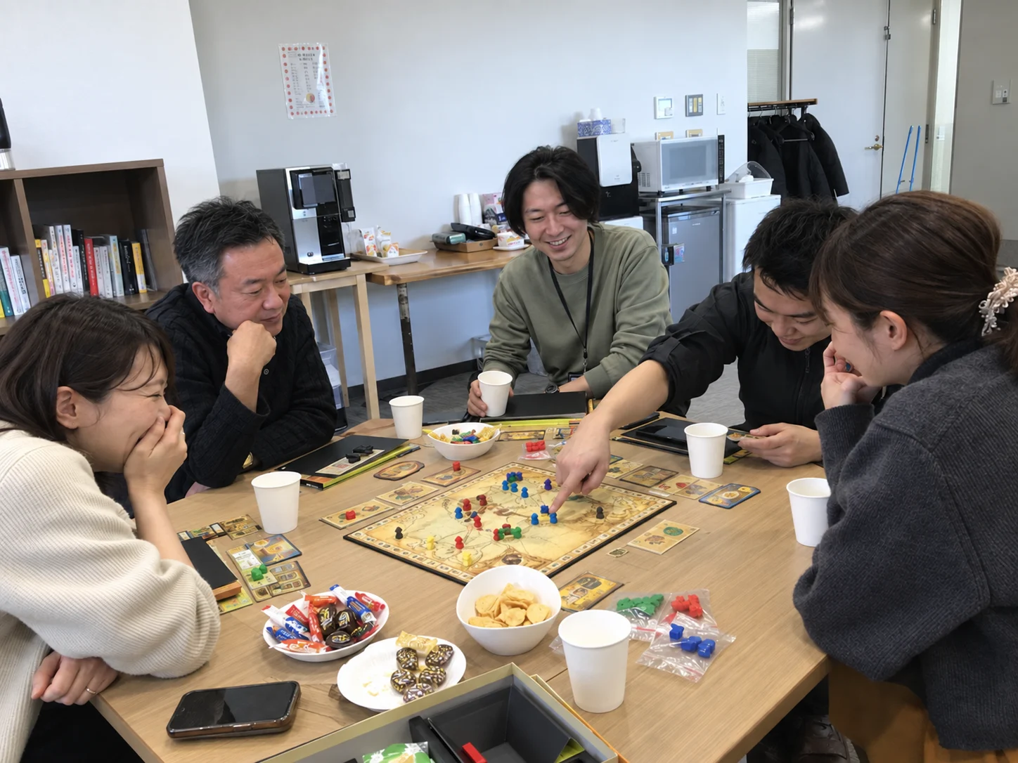 休憩室で社内イベントを楽しむ社員のイメージ
