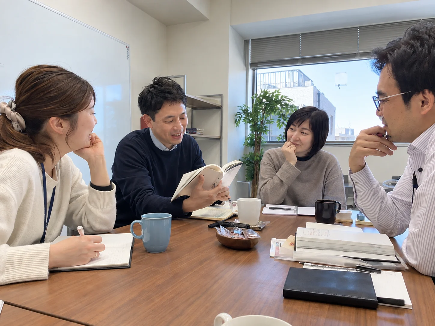 休憩時間に本や資料を囲んで学び合う社員のイメージ
