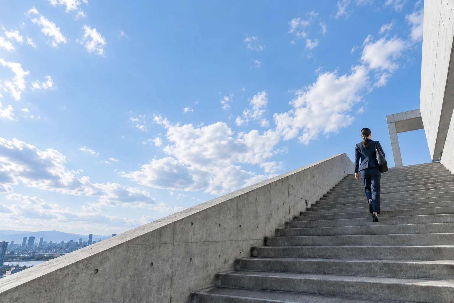 空へ続く階段を歩く社員のイメージ